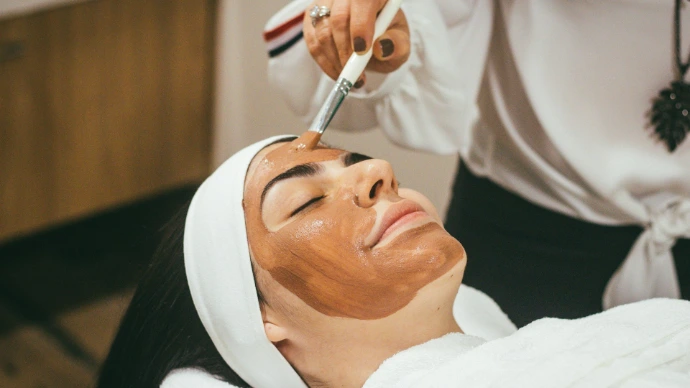 woman receiving facial mask treatment at spa